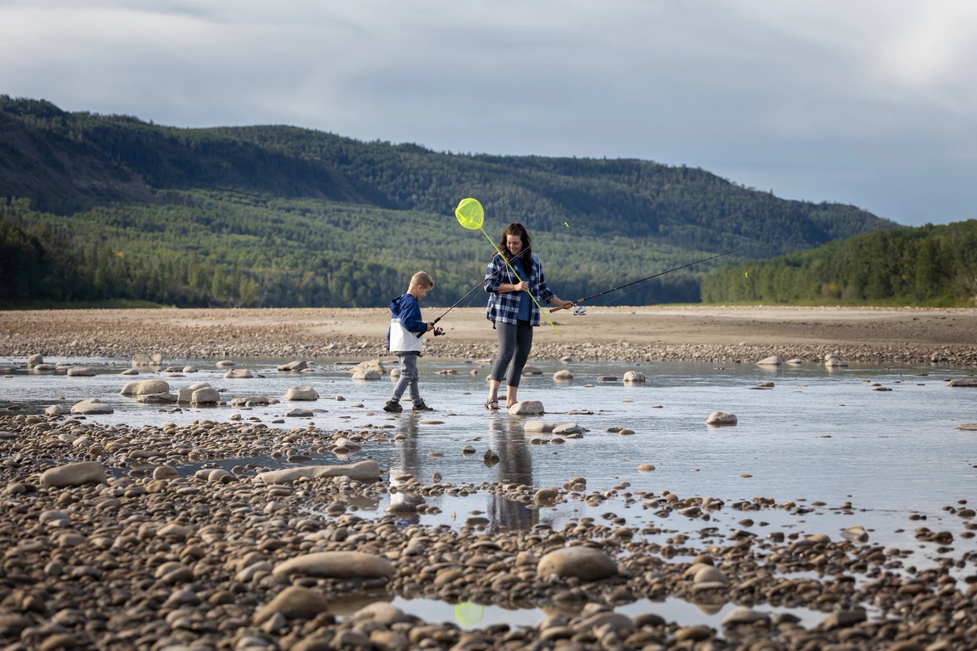 Mom and son fishing on river.