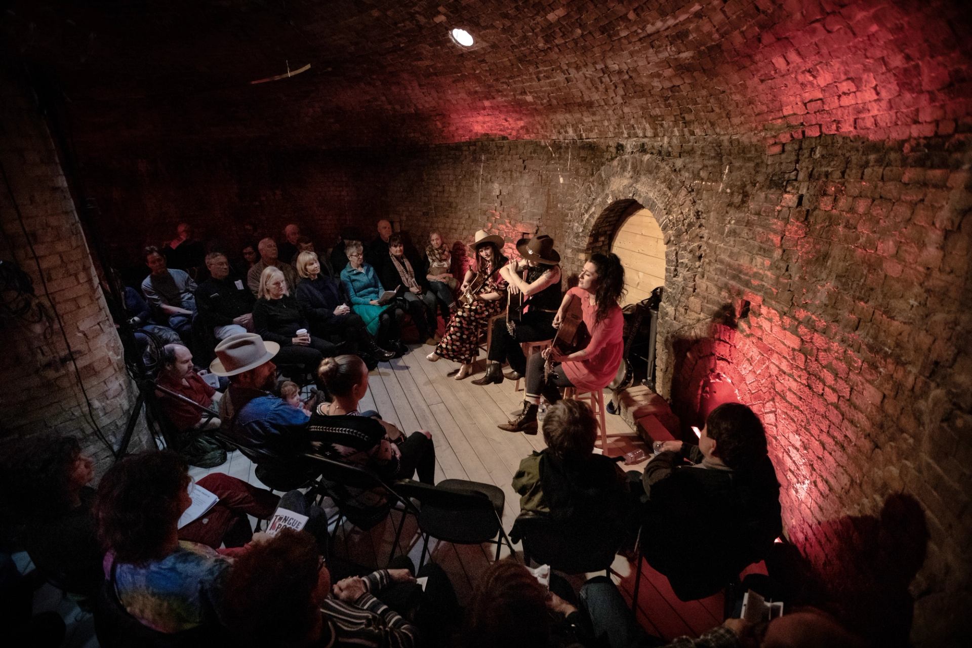 Group of musicians performing at Medalta with brick walls