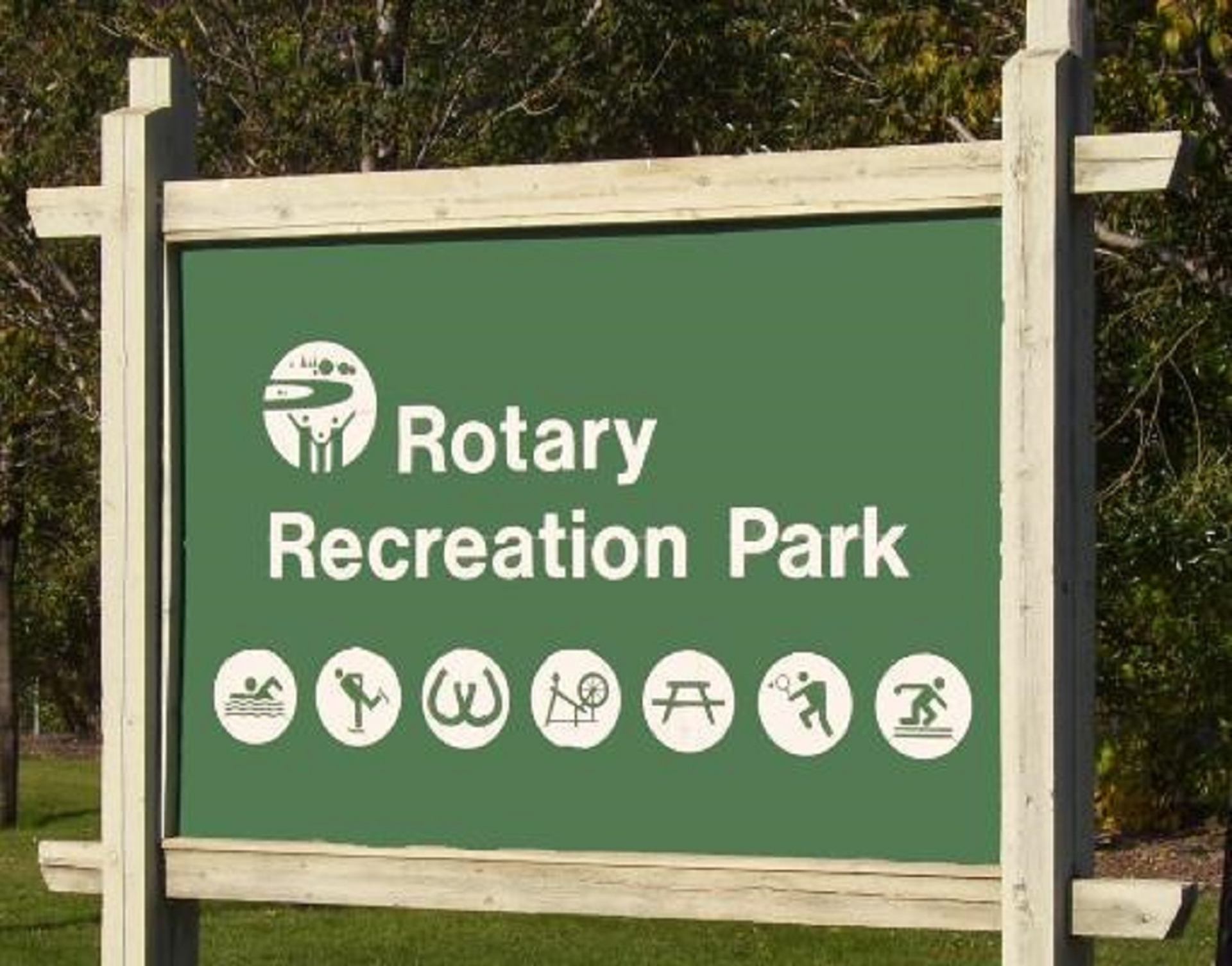Rotary Recreation Park sign with activity icons for swimming, sports, picnics and skating.