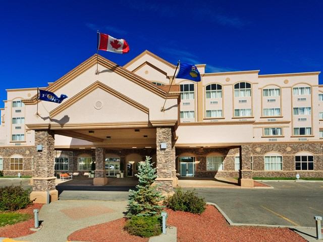 Front view of Holiday Inn with flags and landscaped entrance.