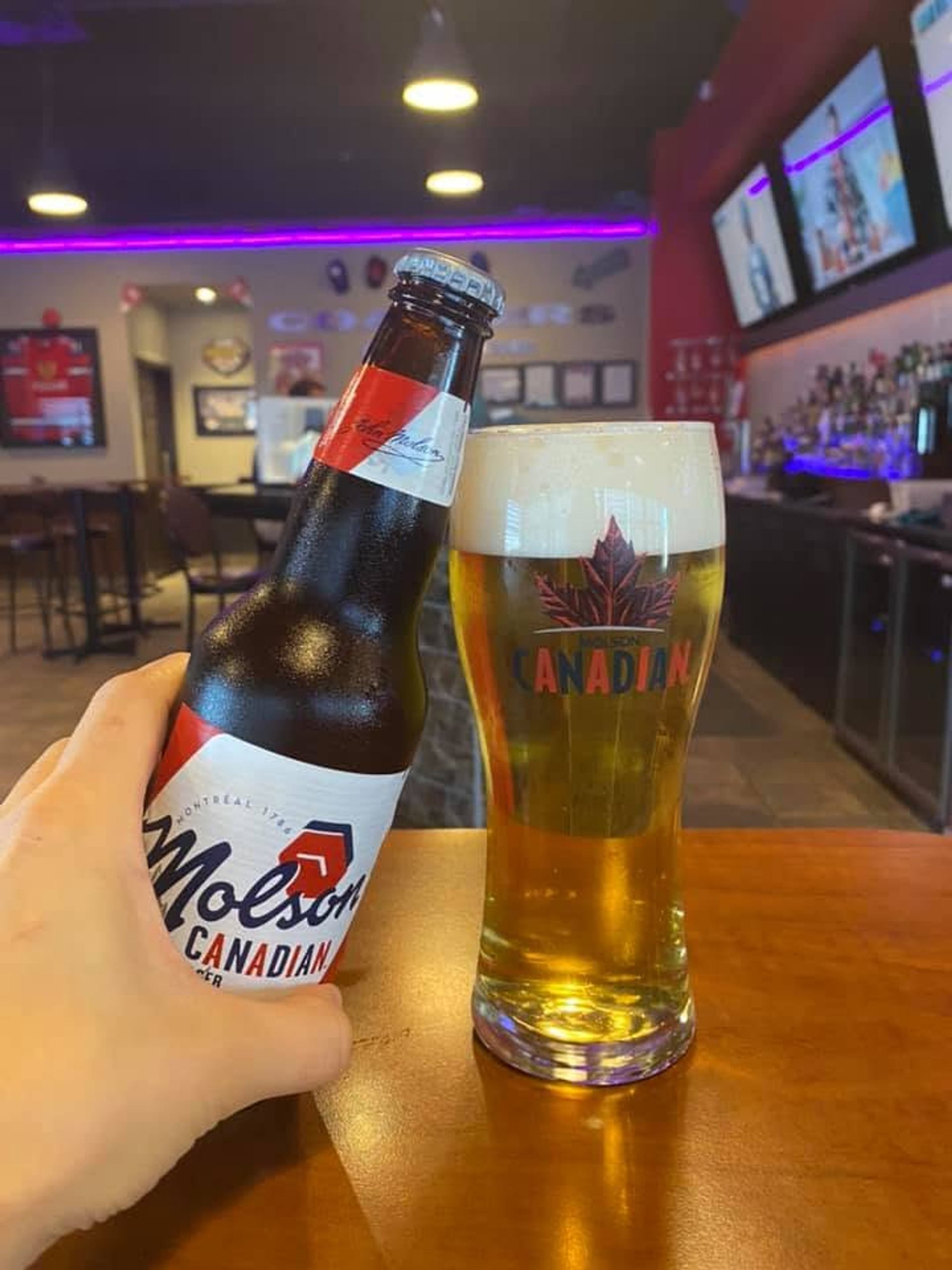 A bottle of Molson Canadian sits beside a freshly poured pint inside Coaster's Sports Bar.