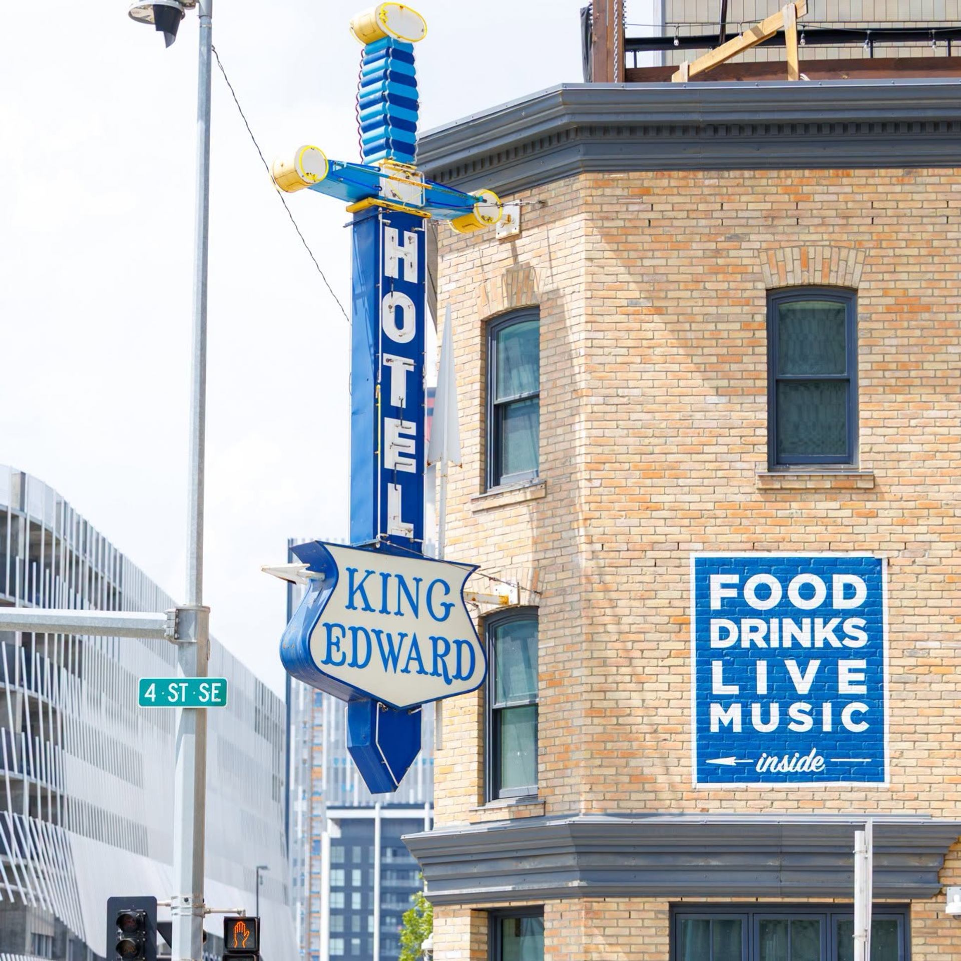Brick hotel corner with King Edward sign and blue mural advertising food, drinks, live music.