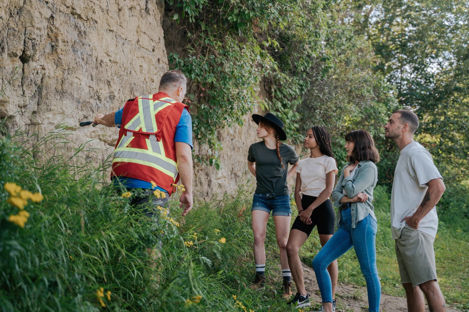 Group observes a geological outcrop during an outdoor educational activity.