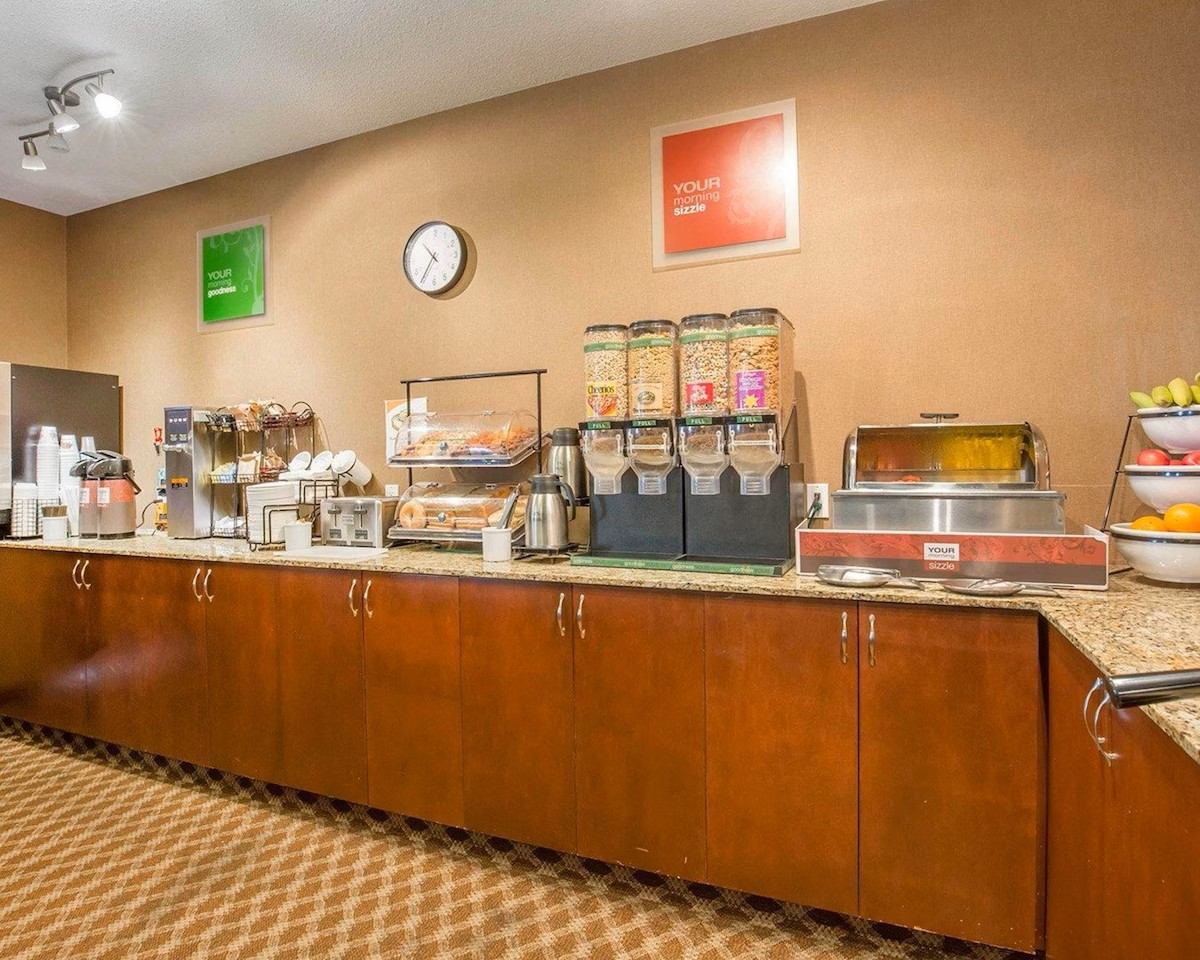 Complimentary breakfast buffet at Comfort Inn & Suites with cereal dispensers, hot food, and fruit.
