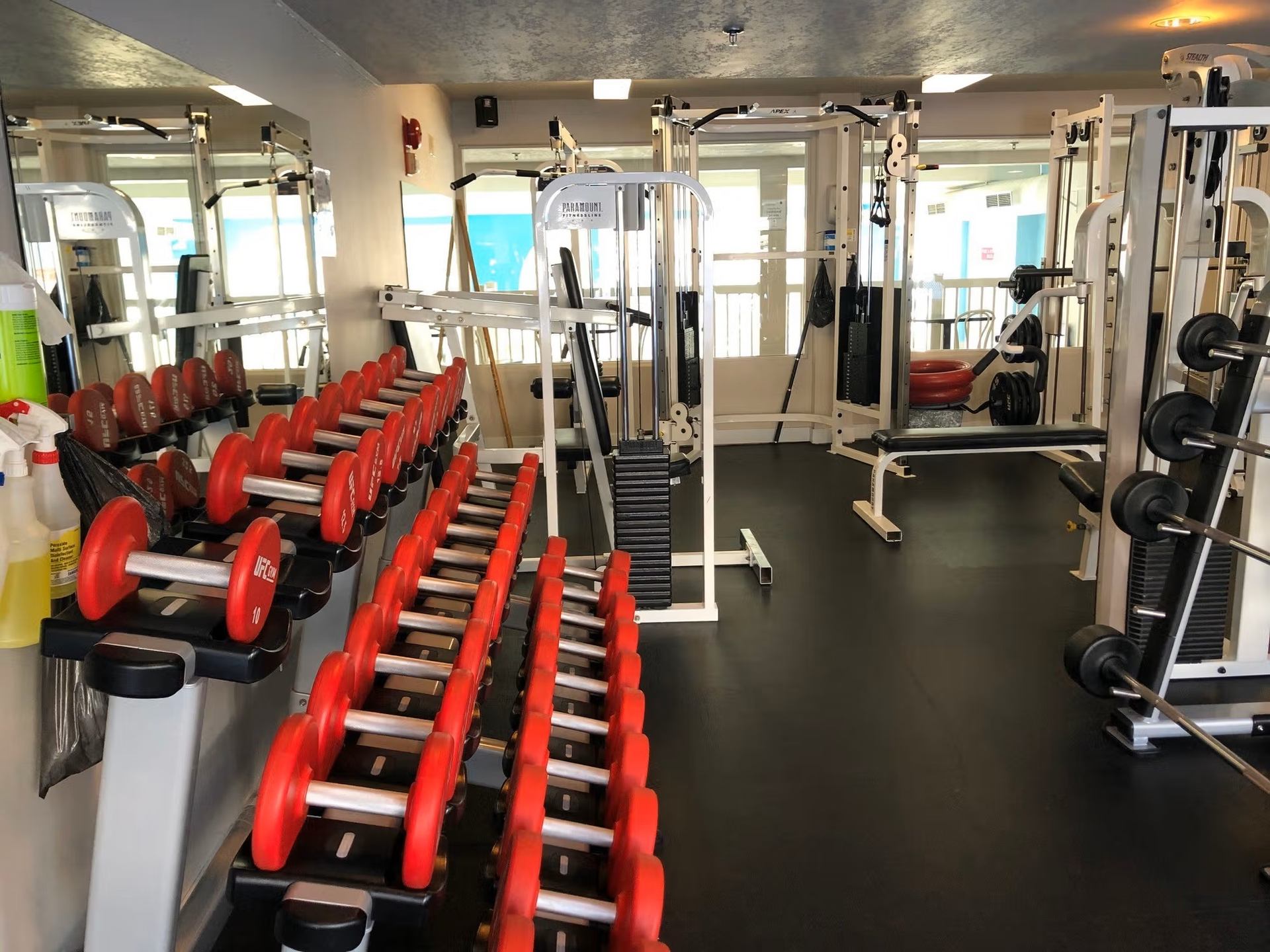 Modern fitness room with free weights and strength training equipment.
