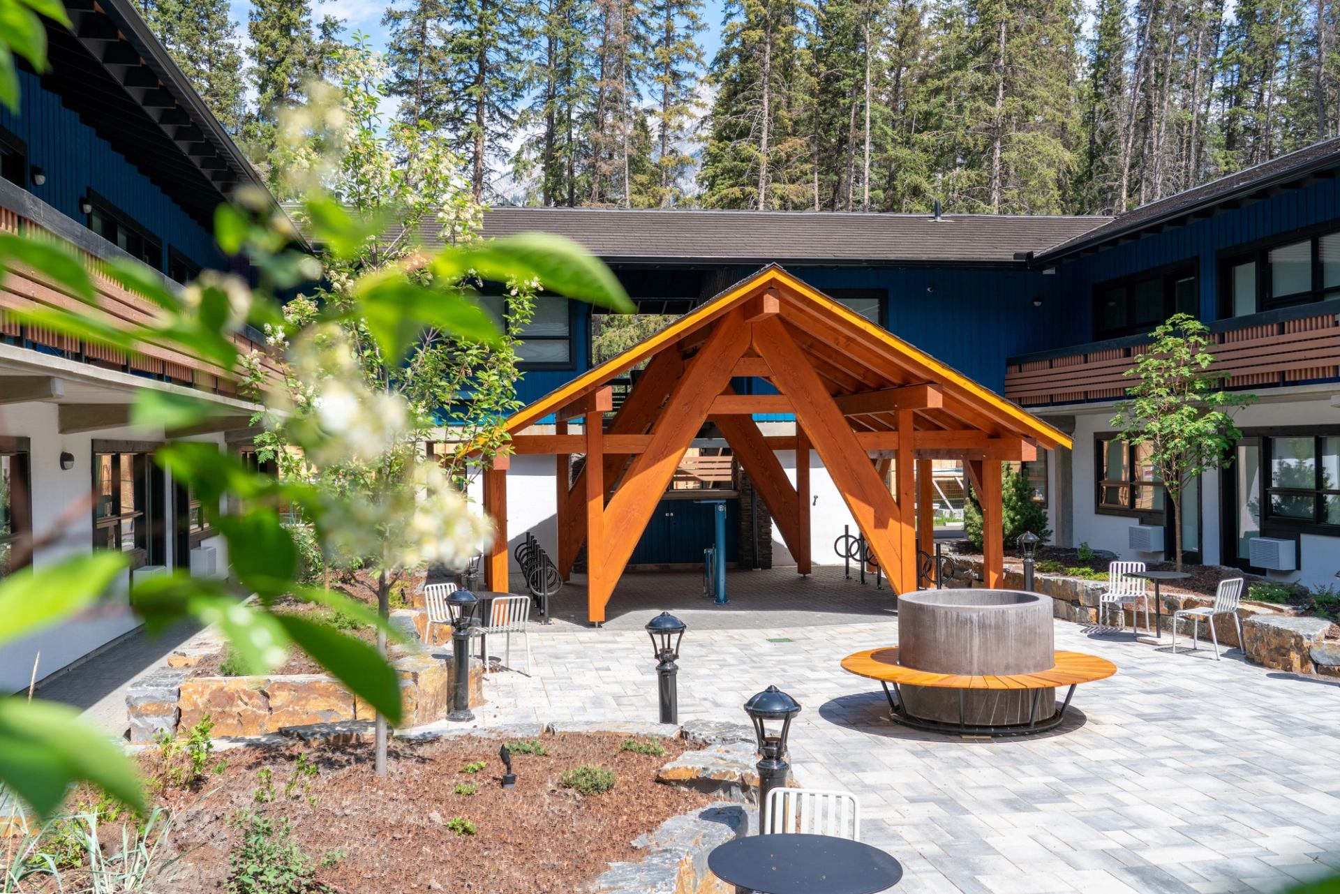 Outdoor courtyard at The Dorothy Motel with fire pit and shaded seating.