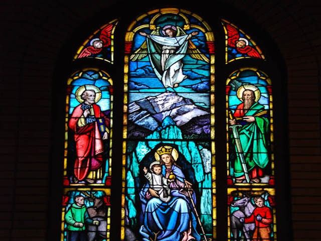 Colorful stained glass depicting religious figures and scenes at St. Mary’s Parish.