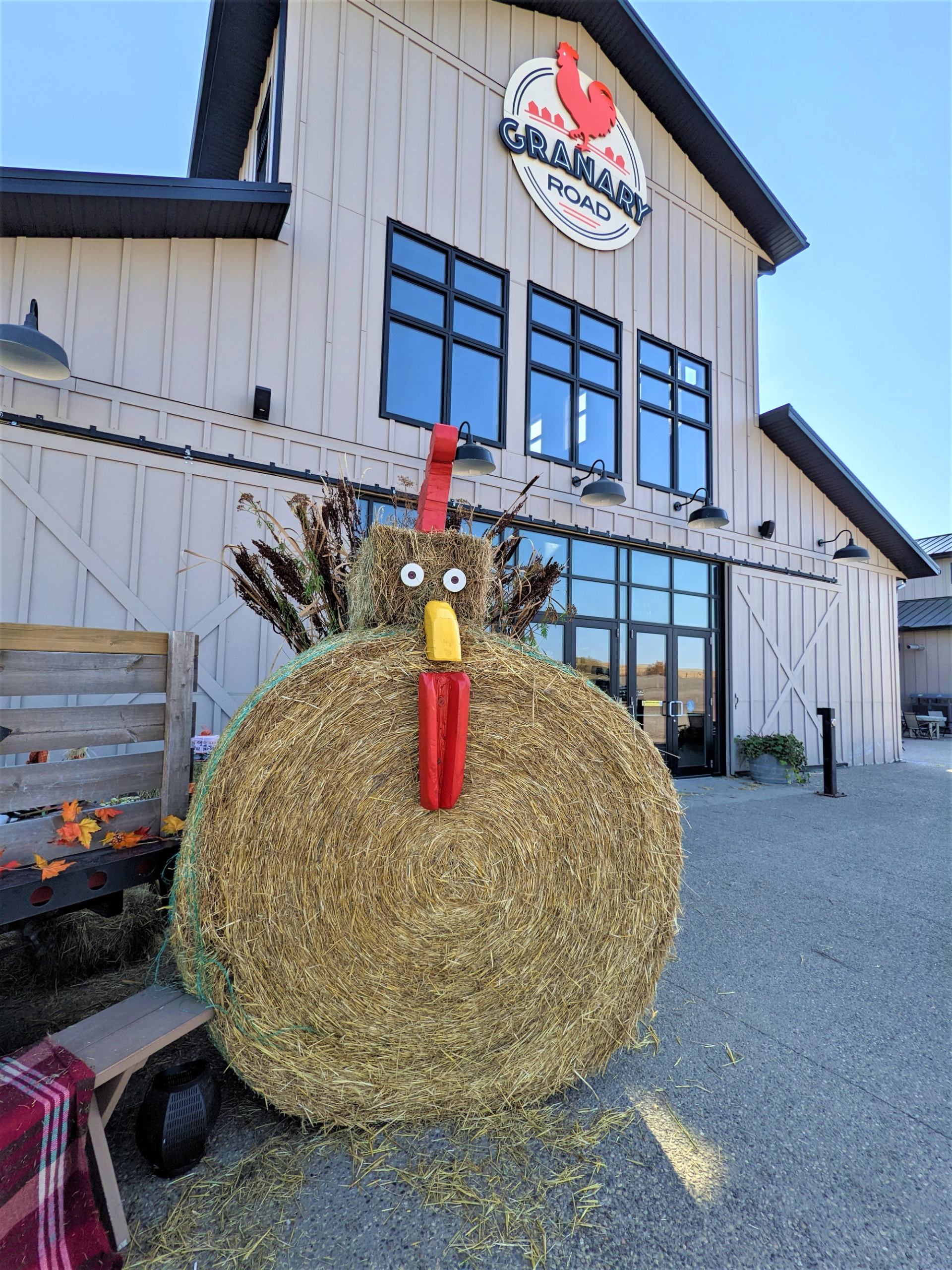 Turkey-shaped hay bale with googly eyes and feathers at Granary Road’s Barnyard.