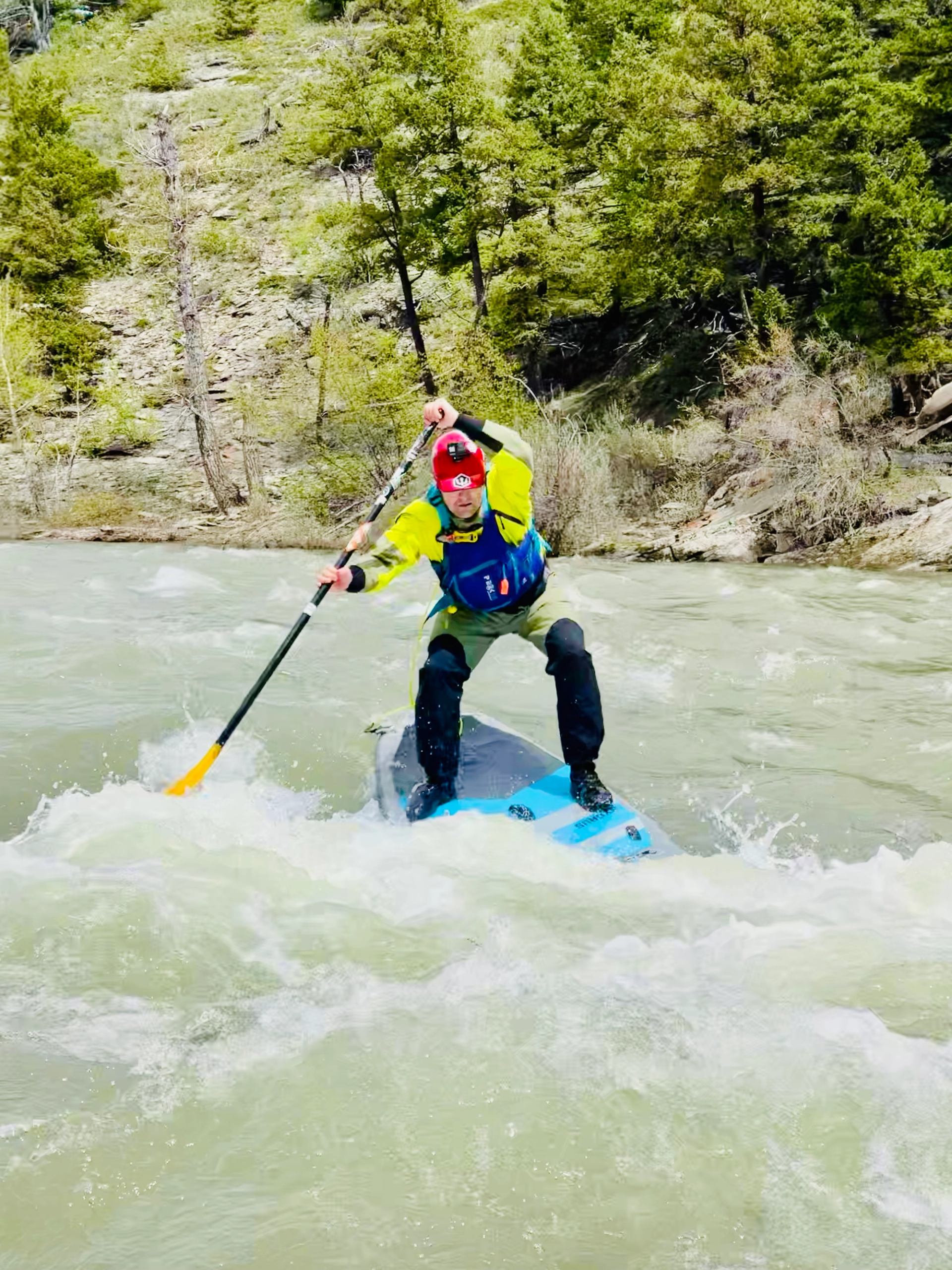 A person stand up paddle boarding on the river