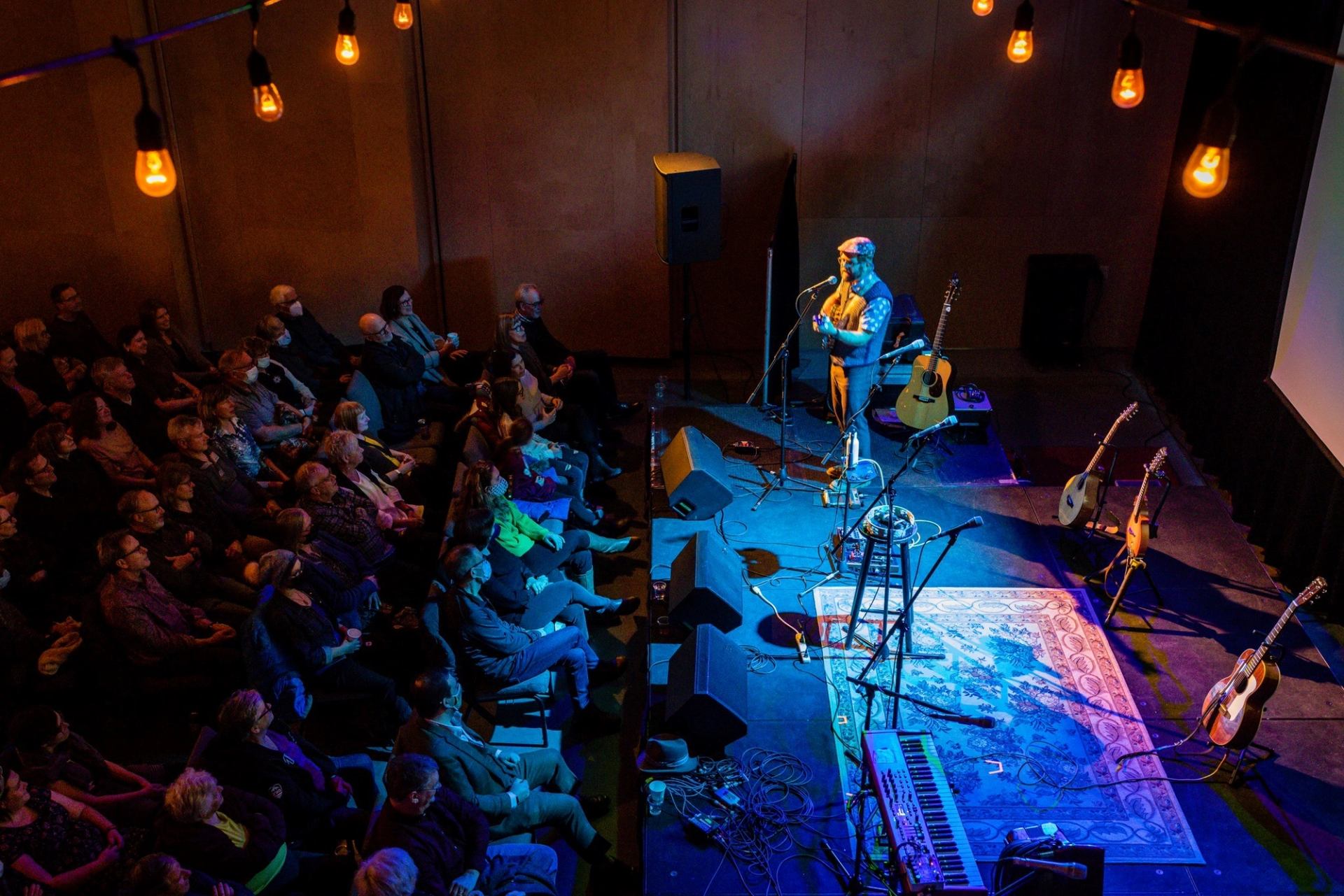 Solo musician performing on stage with guitars at Block Heater festival.