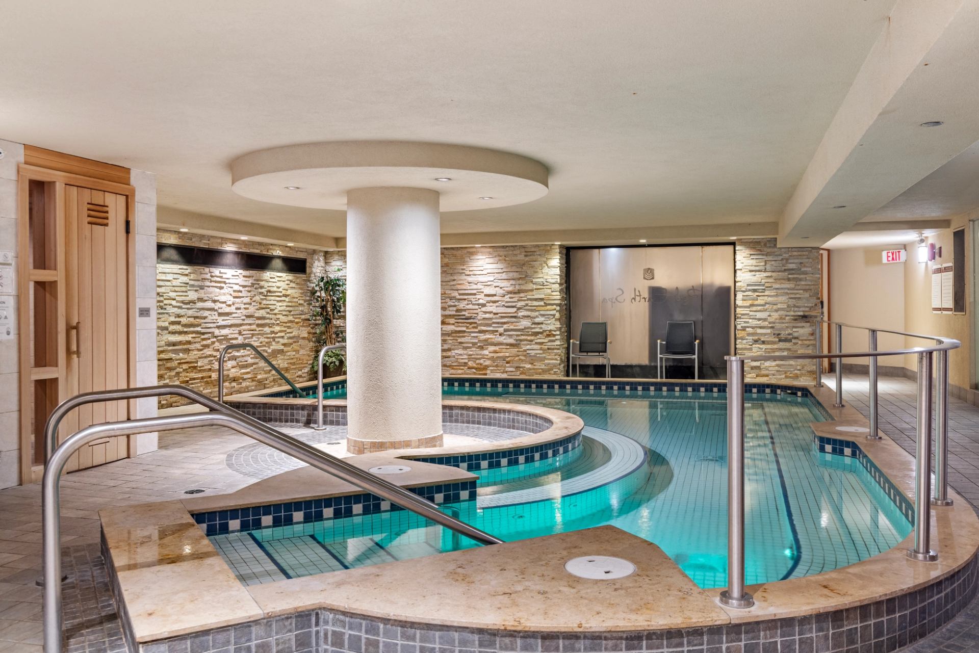 Hot pool with railings around the edge, a sauna on the left side.