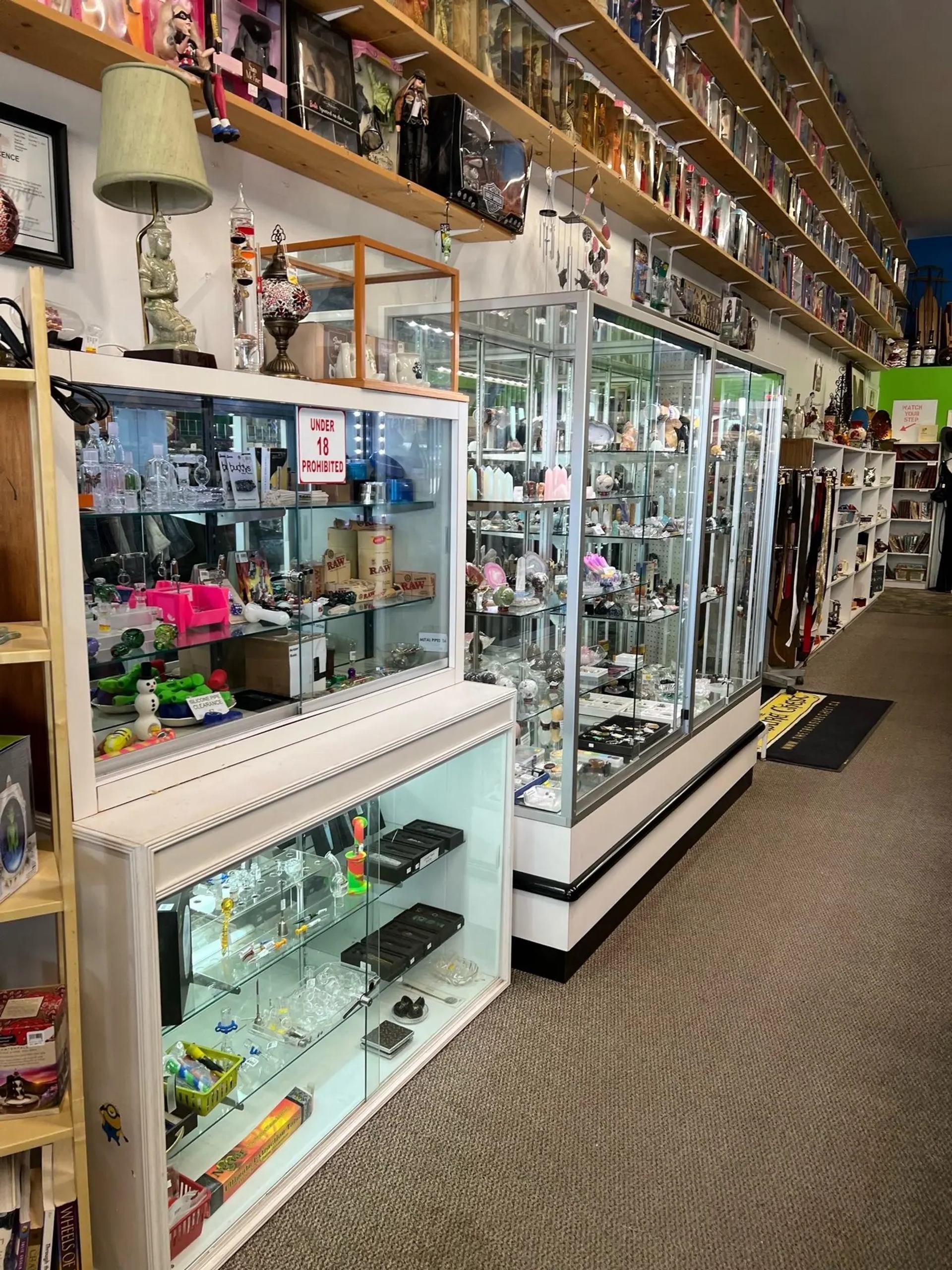Glass display cases filled with collectibles and antiques inside The Treasure Chest store.