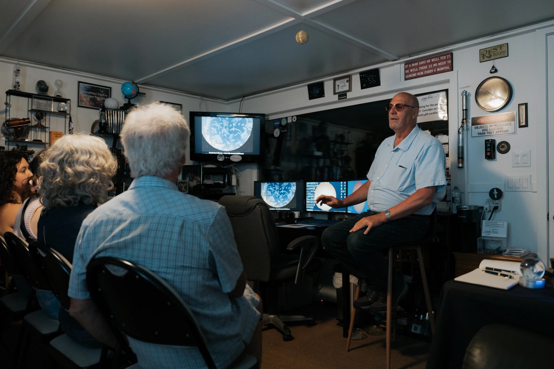 Indoor astronomy session with screens showing star maps and celestial charts
