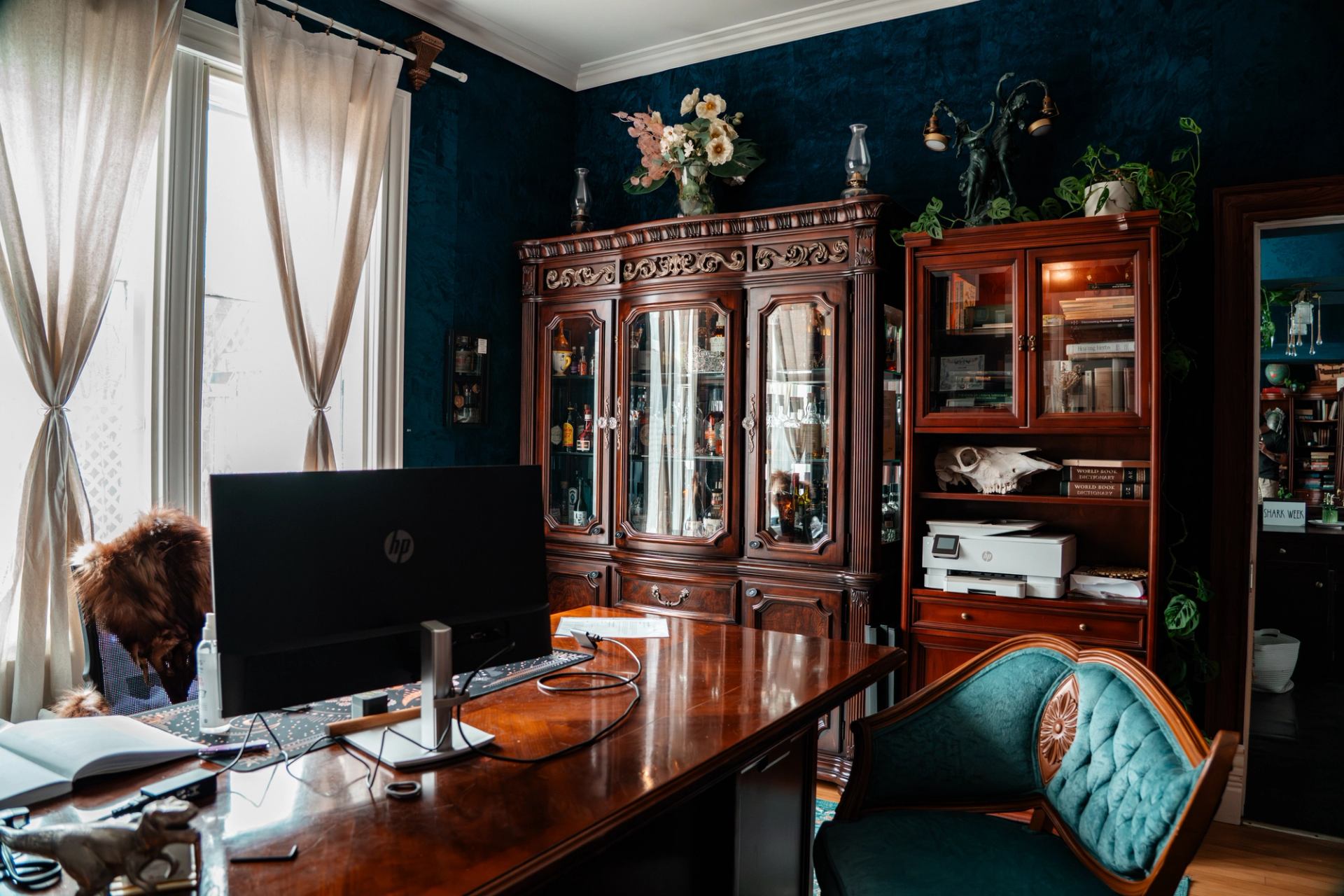 From the business's view, a richly decorated room showcases antique wood furniture, shelving, and soft light.