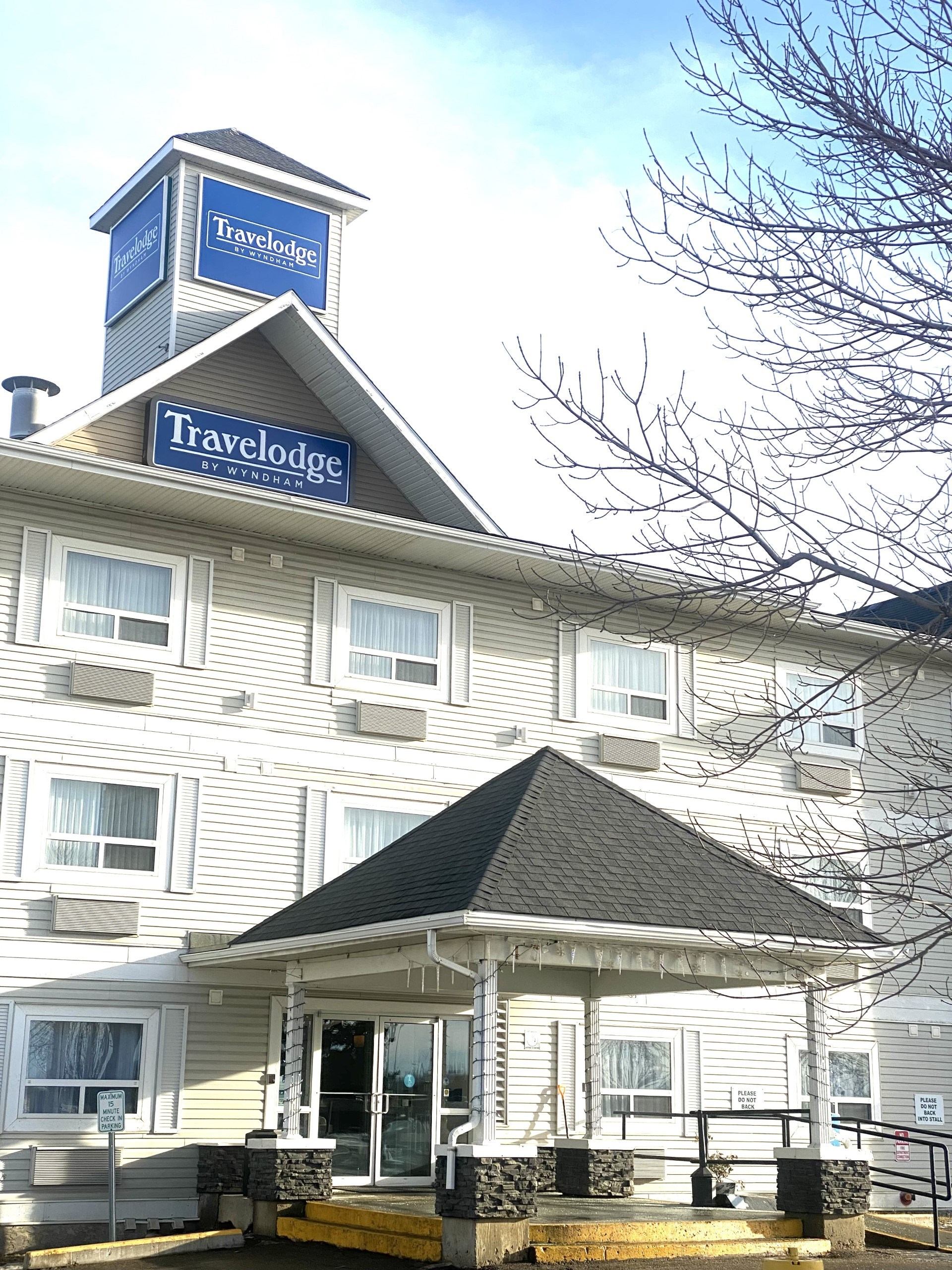 Travelodge hotel exterior with Kingston sign and clear blue sky.