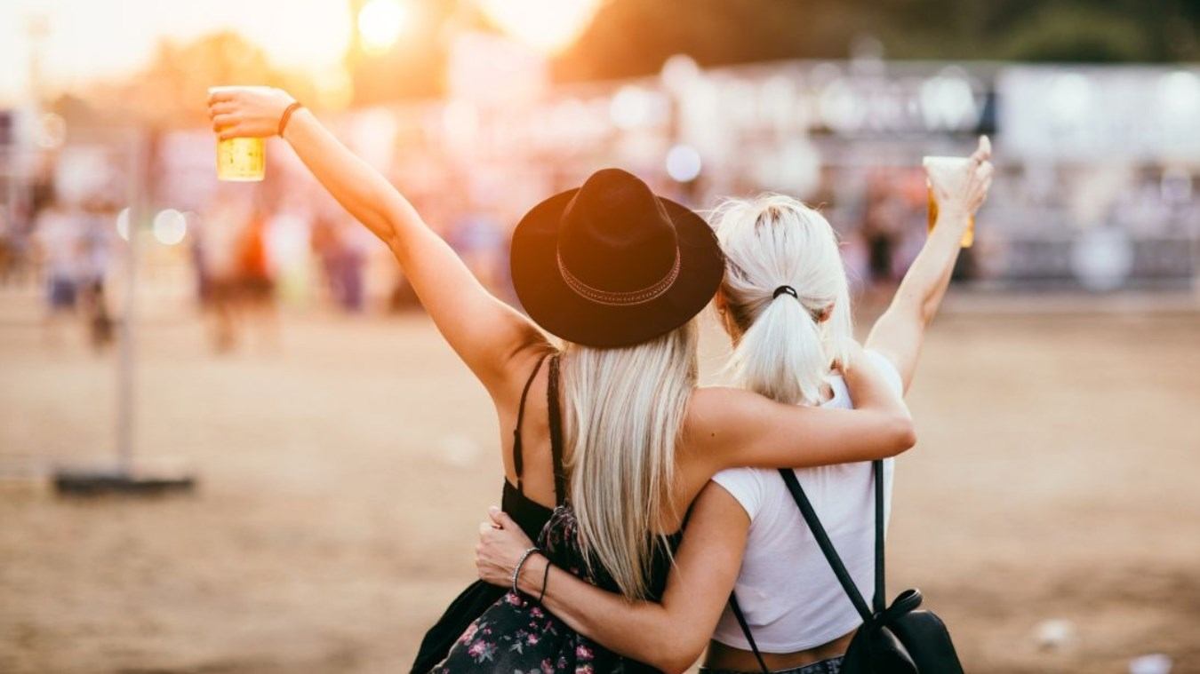 Two ladies with their arm around each other enjoying the festival.