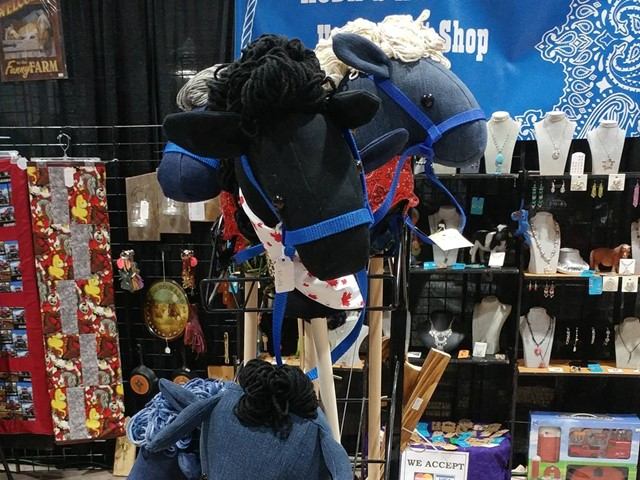 Retail store display with stuffed animals, jewellery, and keychains on racks and stands.