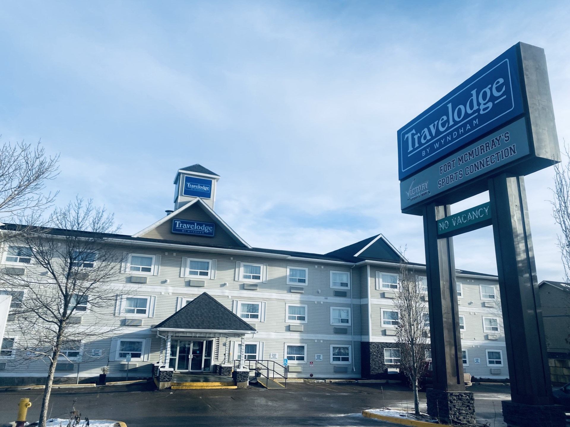Exterior of Travelodge hotel with signage and clear sky.
