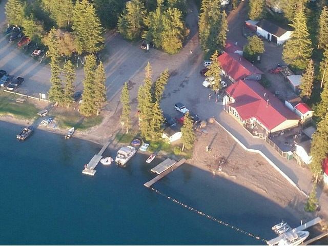 Bodina Resort marina with boats, dock, red-roof buildings, and lakeside parking area.