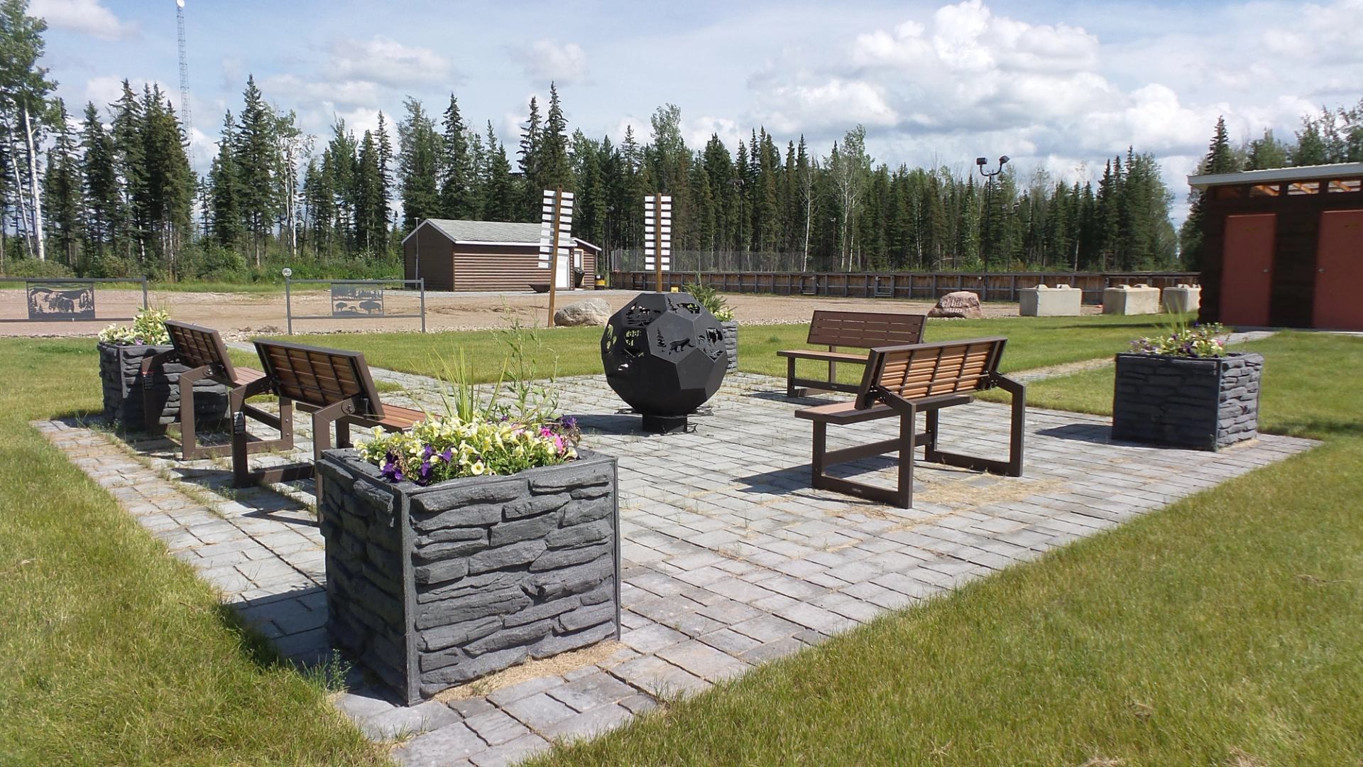 Benches and stone planters arranged on paved area in Zama Community Park