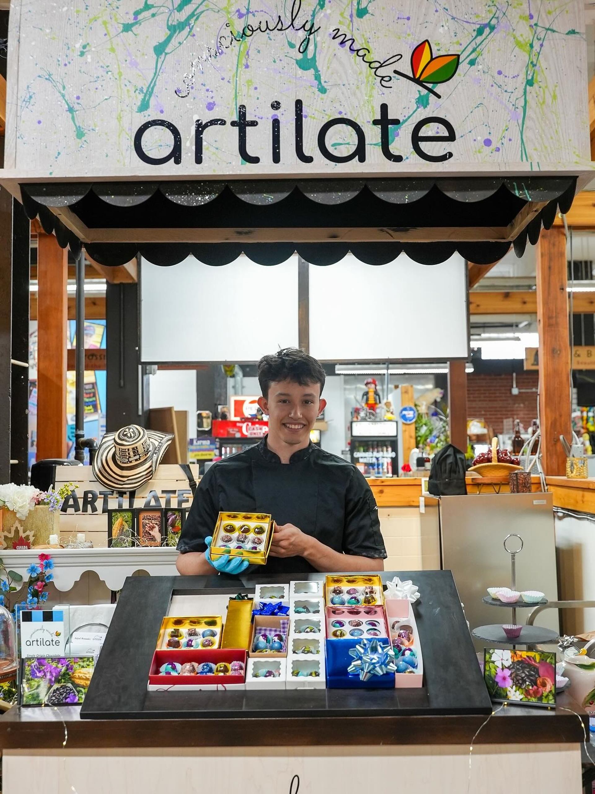 Vendor booth at Crossroads Market with vibrant art pieces and crafts on display.