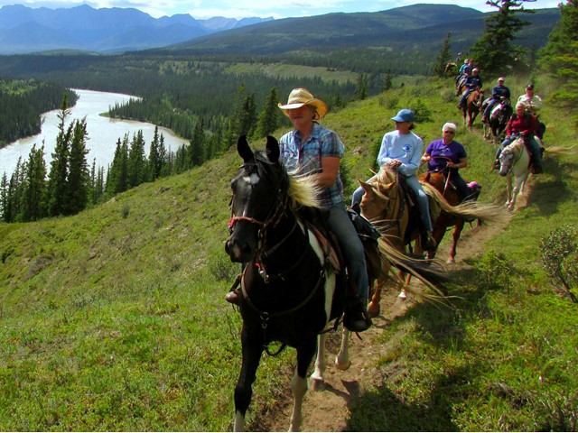 A group of people riding horses on the tail