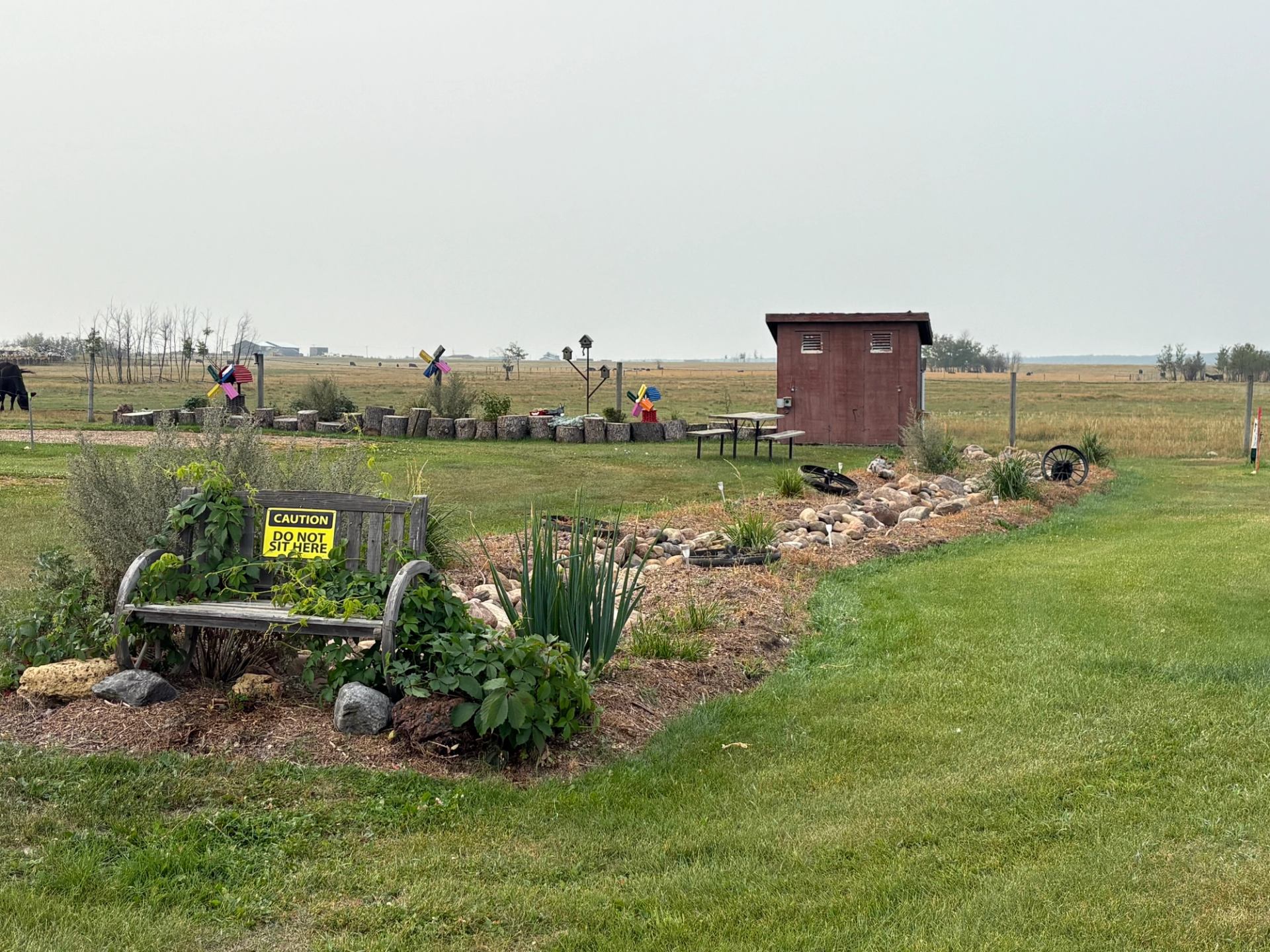Garden area with benches and a small shed at Lamont RV Park and Campground.