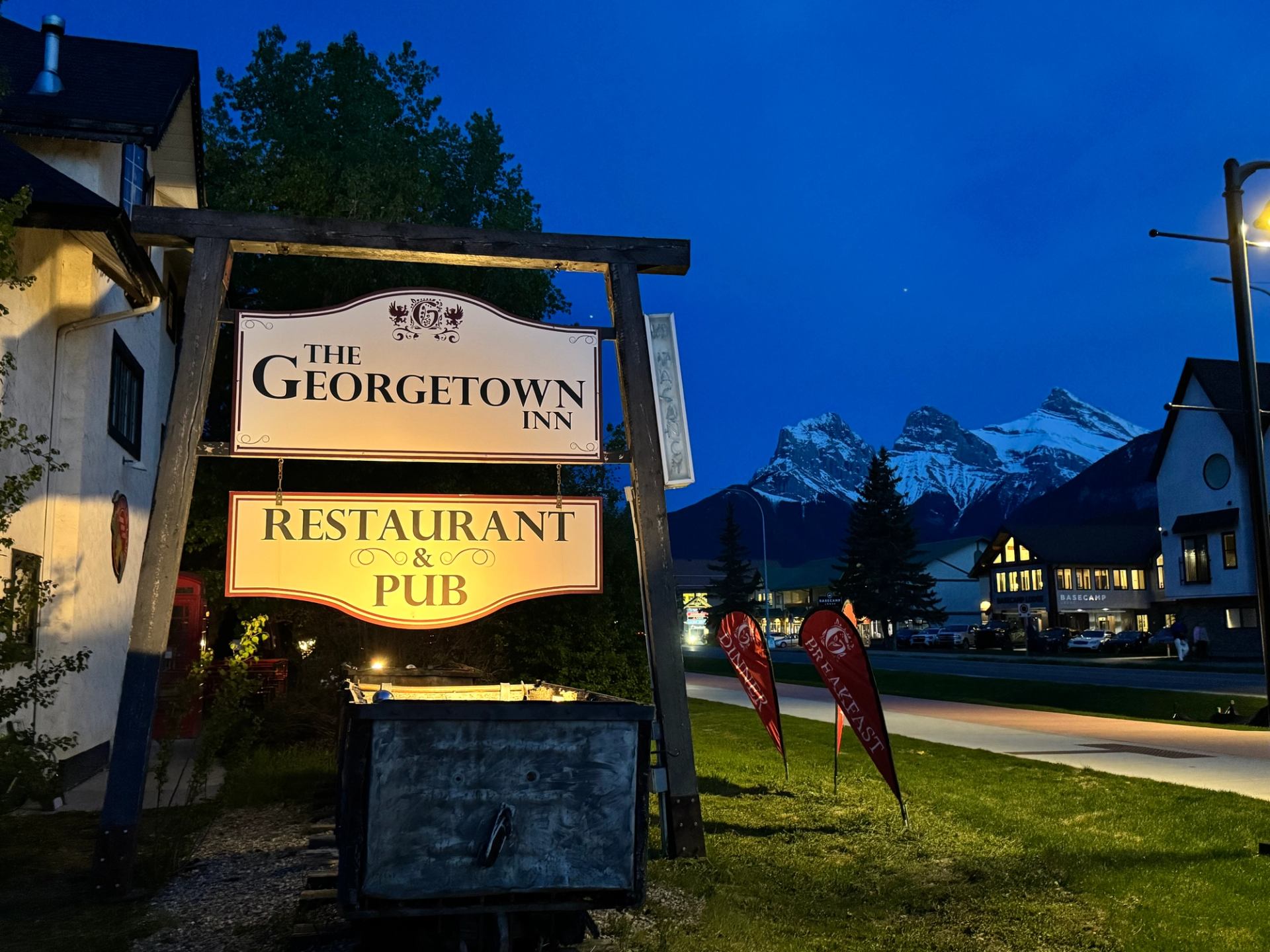 Georgetown Inn sign glowing at night with mountain backdrop.