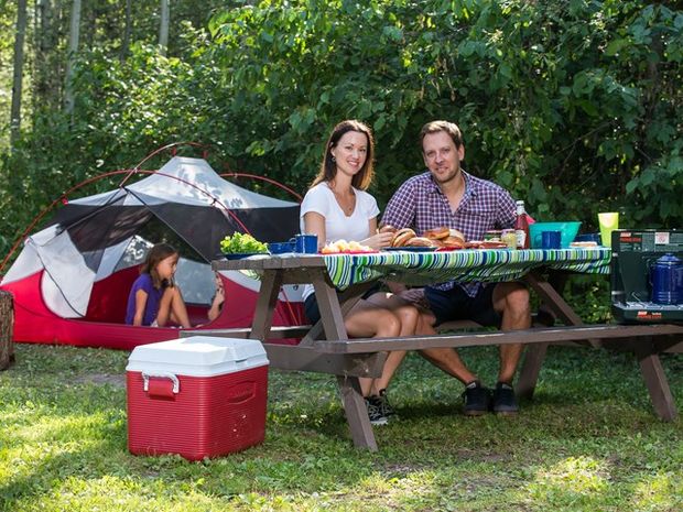 Couple eating while their kids play in the tent.