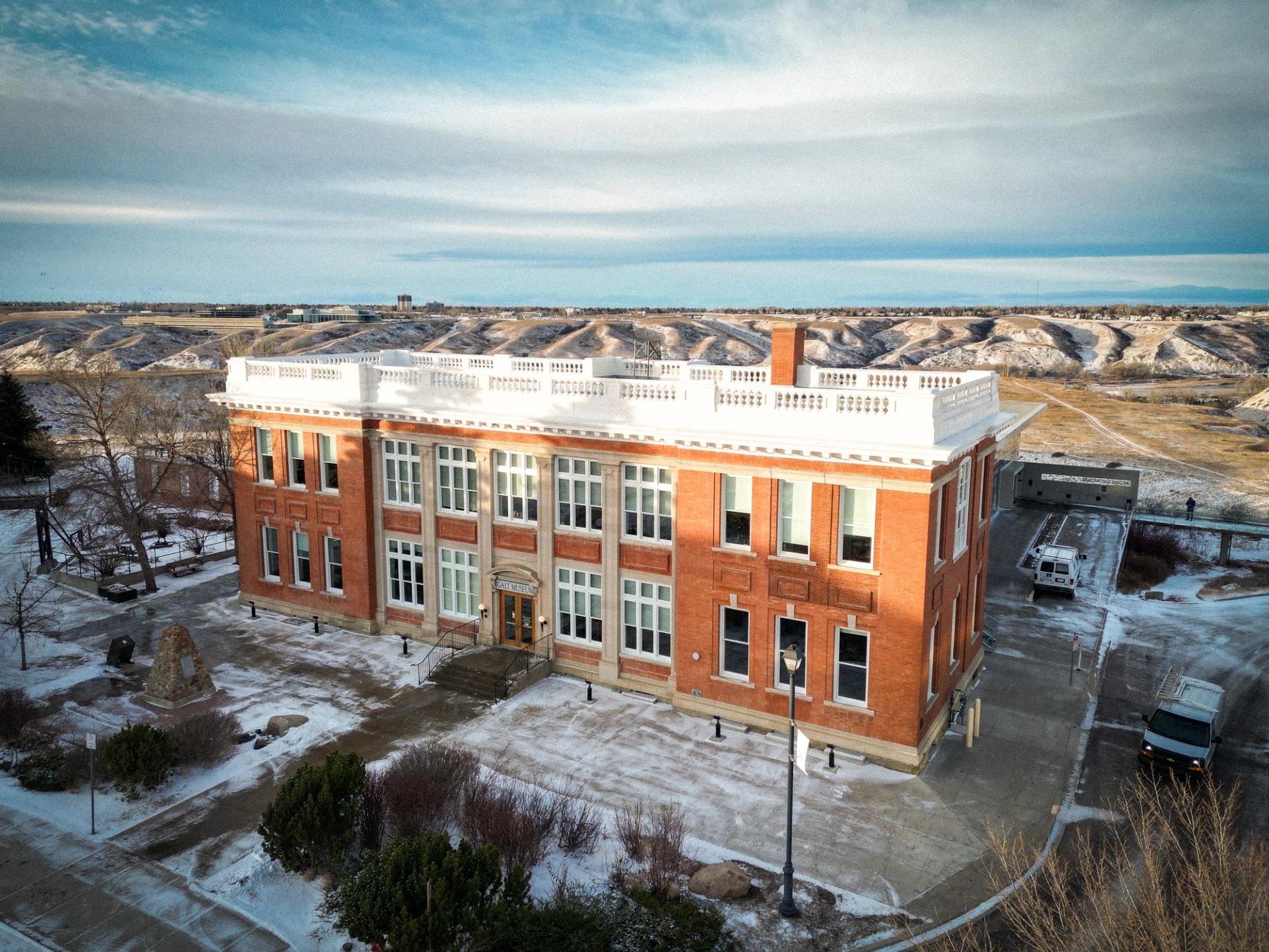 Brick Galt Museum building in winter with scenic hills in the background
