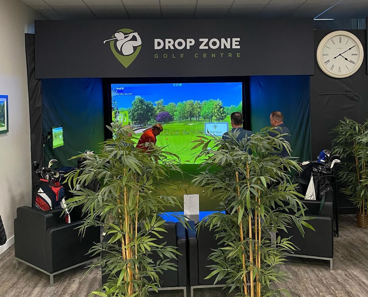Golf simulator setup with players and greenery in view