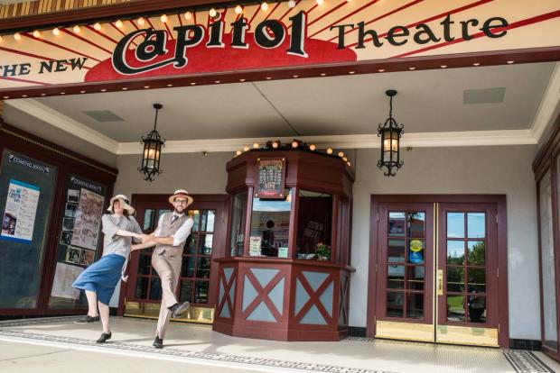 Historical actors dancing in front of the Capitol Theatre in Fort Edmonton Park.