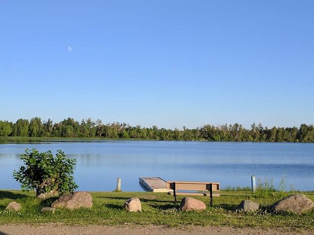 The beach area with a park bench