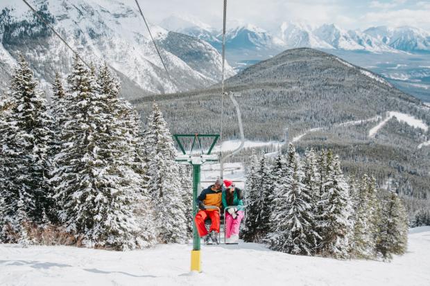 Friends riding up the sightseeing chairlift at Mt.Norquay in Banff National Park