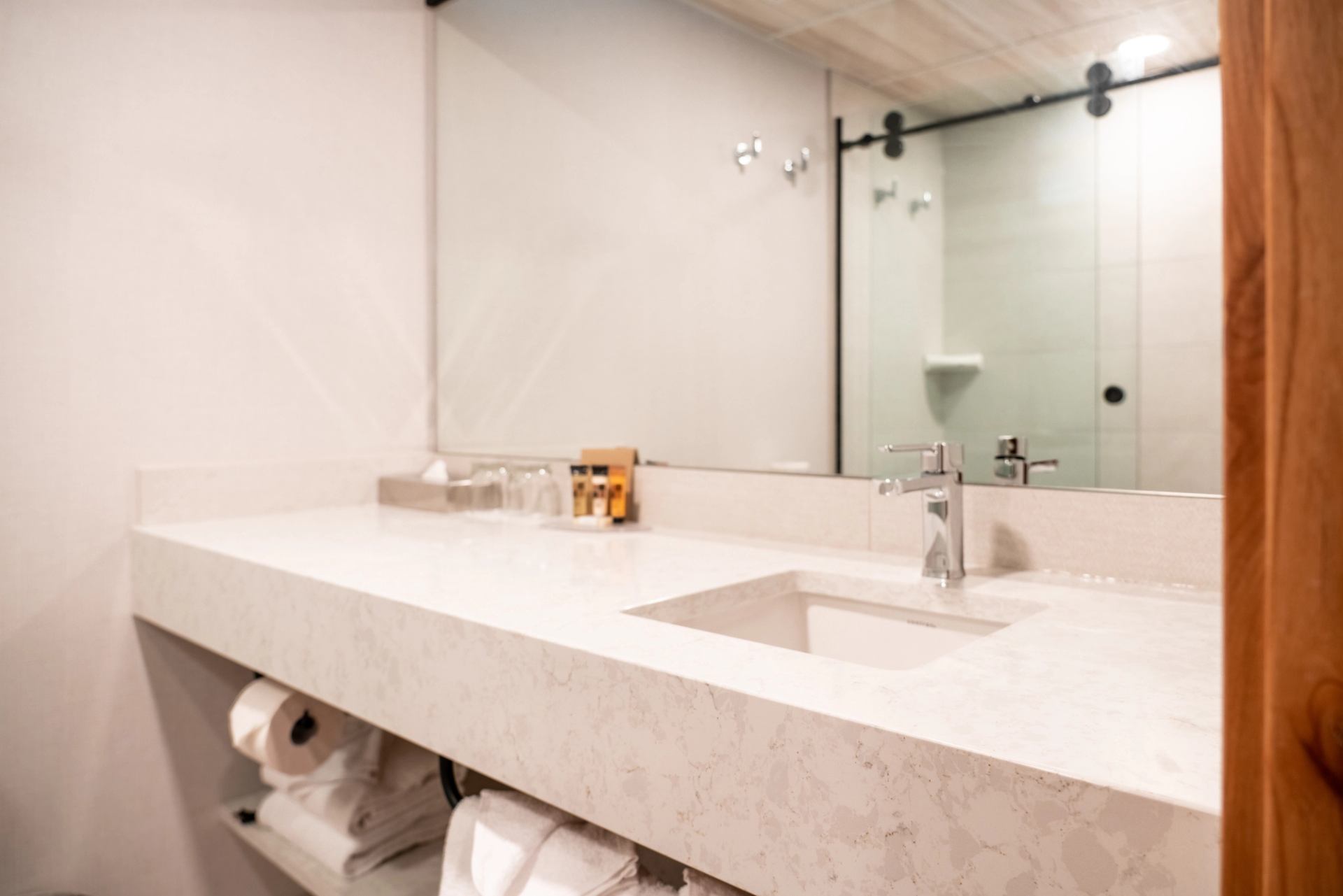 Modern bathroom at The Dorothy Motel with glass shower and sleek vanity.