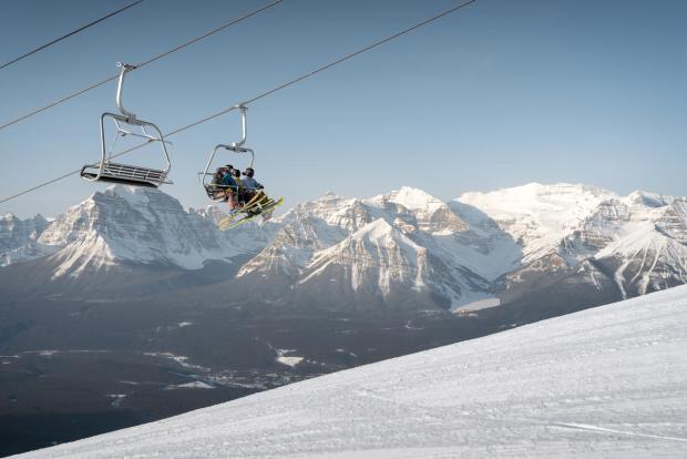 Skiers and snowboarders ride the chairlift before skiing at Lake Louise Ski Resort in Banff National Park