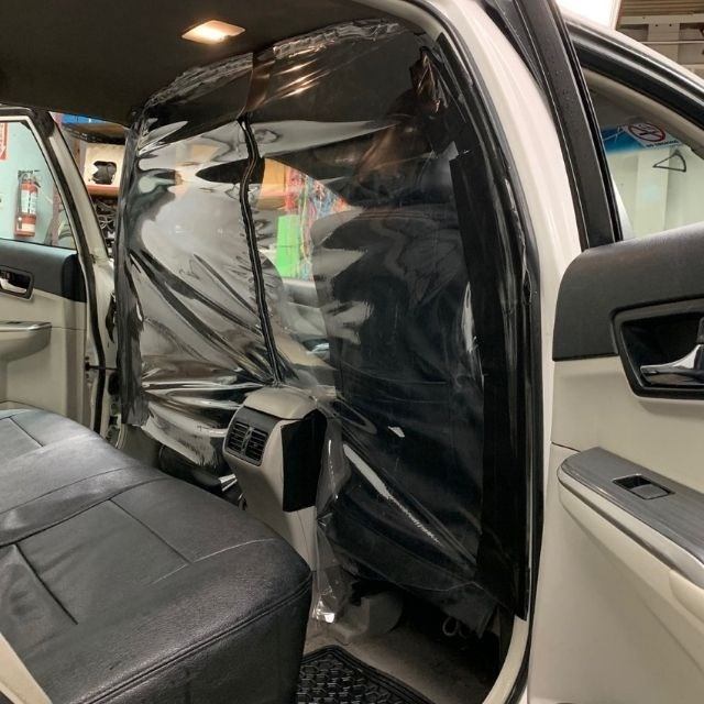Interior of taxi showing clear safety barrier between front and back seats.