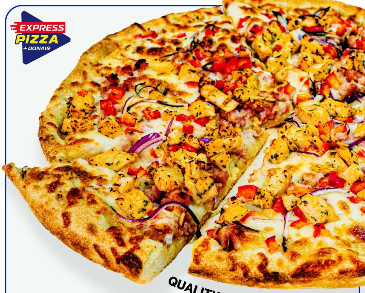Pan-proofed pizza with chicken, bacon, ranch, red onions, and red peppers on a golden crust.