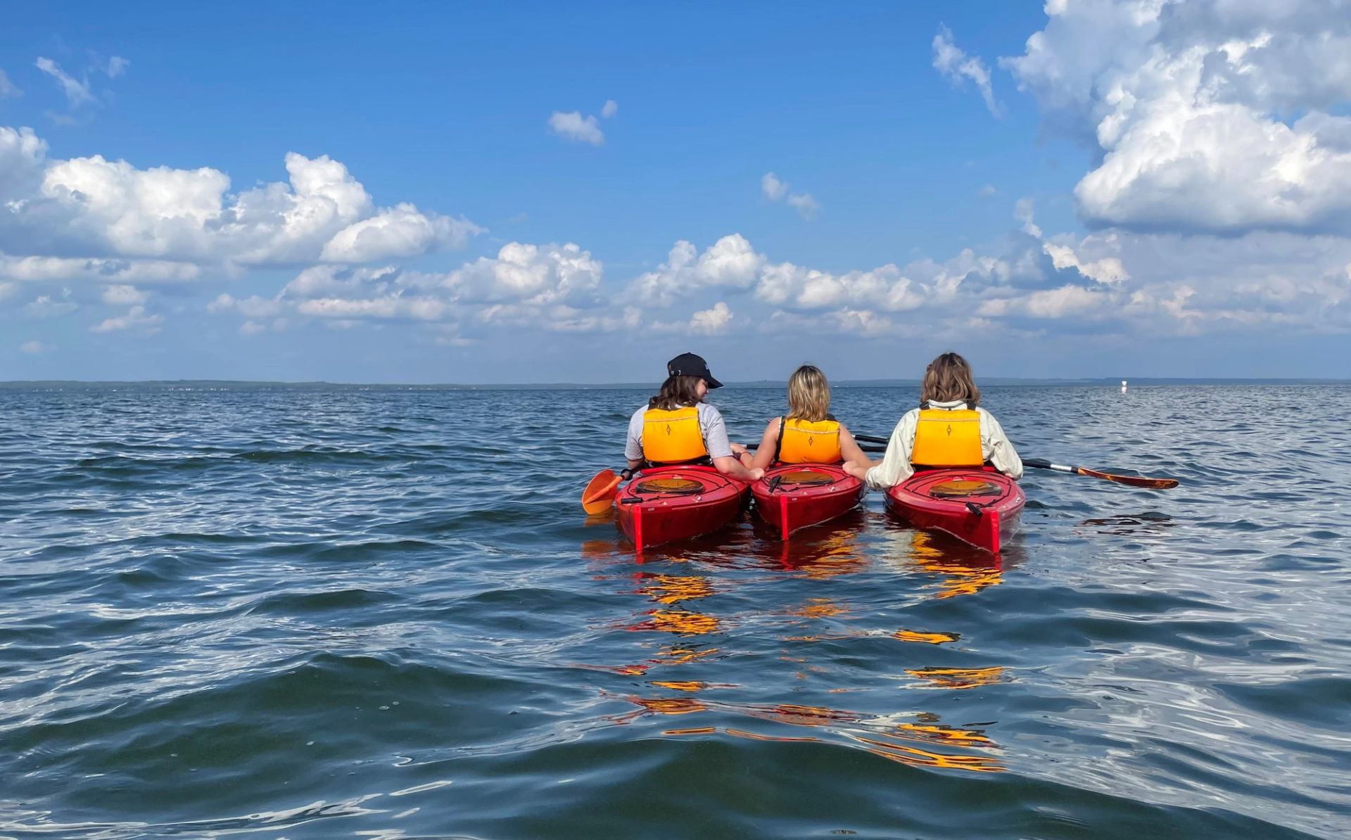 Three people kayaking on the lake.