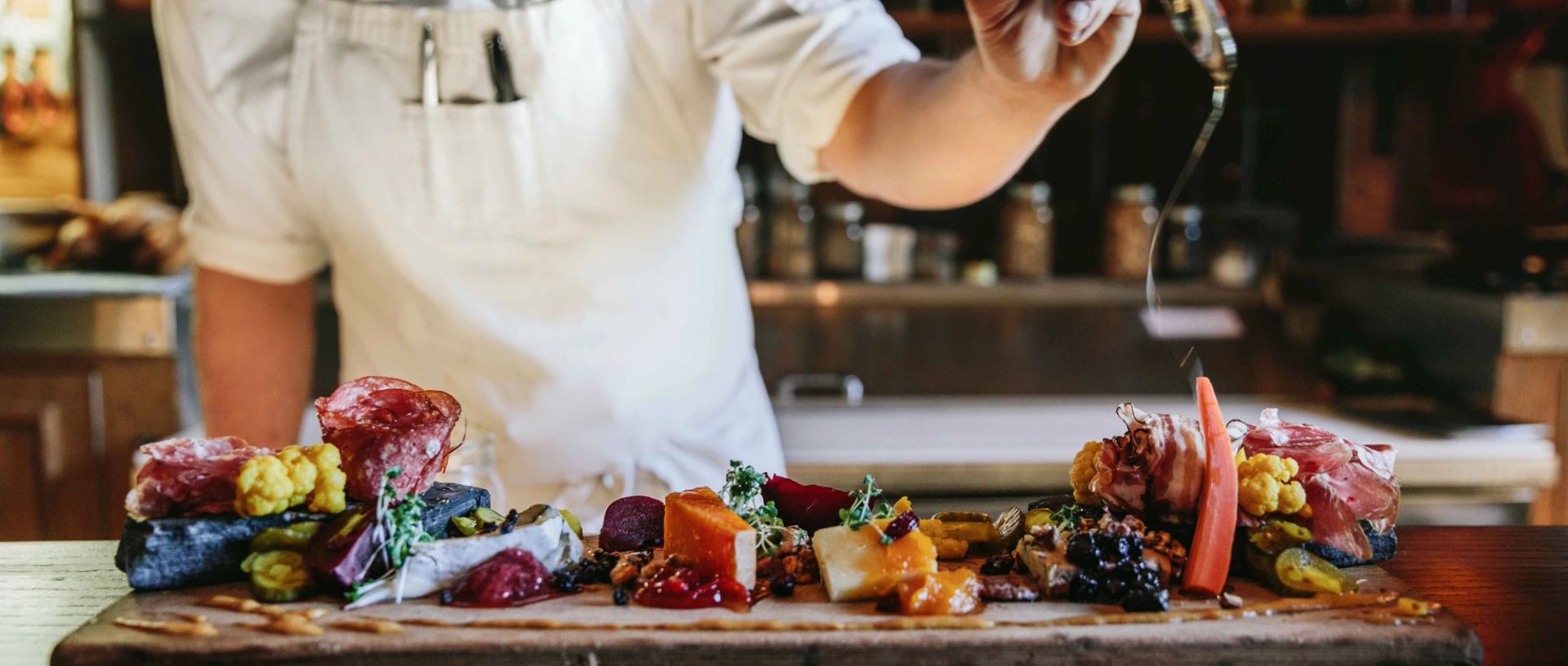 Chef preparing a colorful charcuterie board at Grapes Wine Bar.