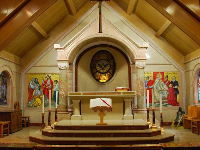 Altar inside St. Mary’s Parish with stained glass and religious artwork.
