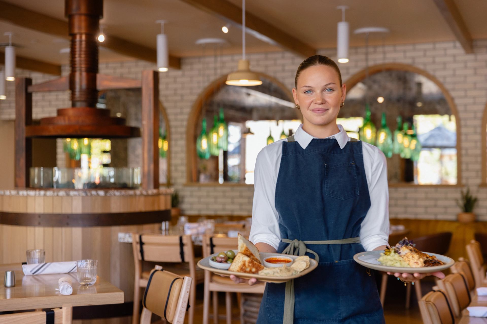 Sudden Sally server smiling and holding a plate of food in each hand
