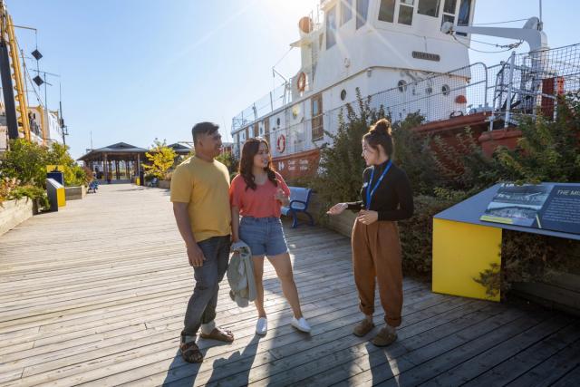 Couple talking to interpreter at the Fort McMurray Heritage Shipyard.