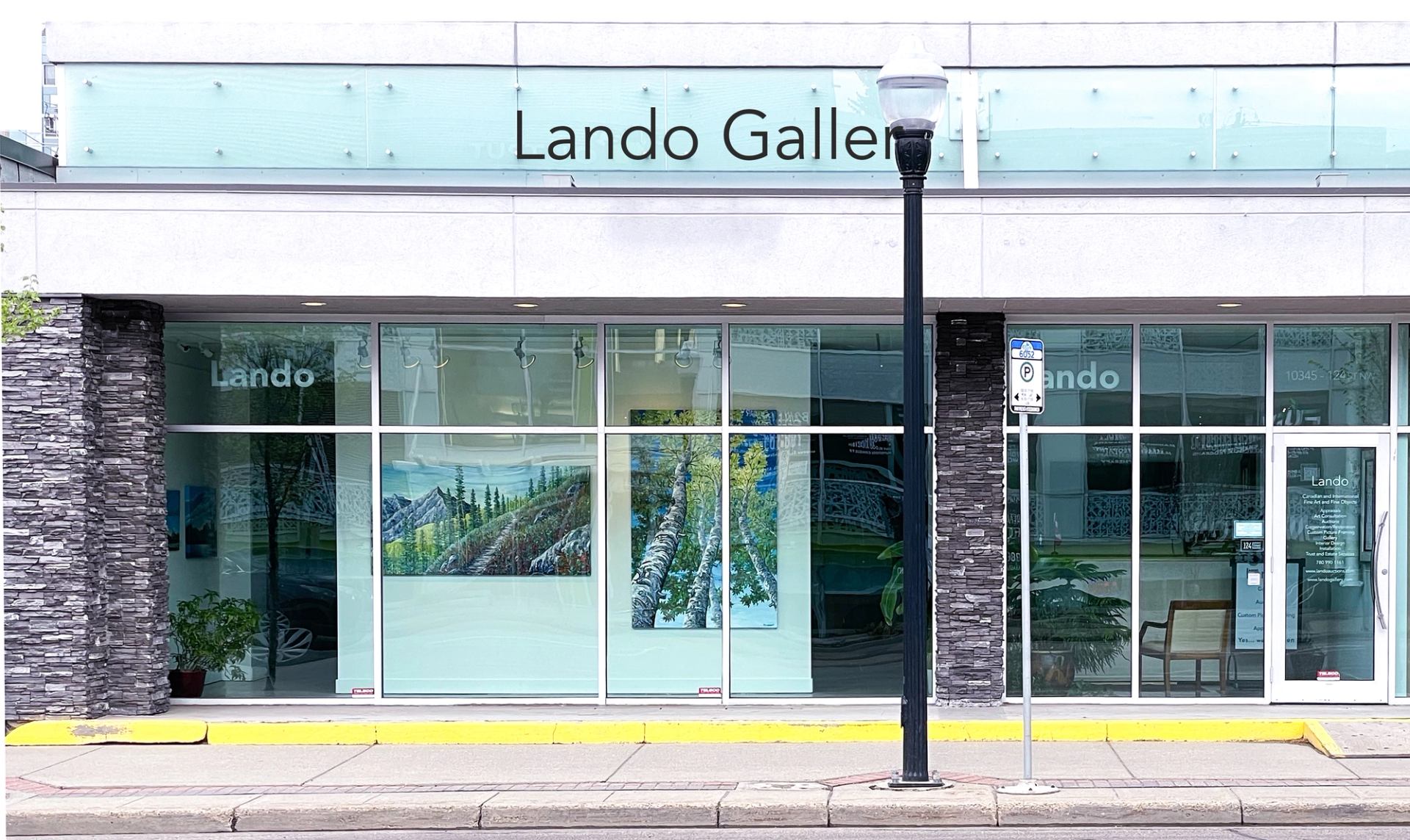 Exterior view of Lando Gallery with large glass windows displaying artwork and a modern facade.