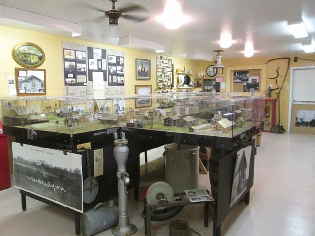 Museum exhibit featuring historical artifacts and a detailed miniature town display.