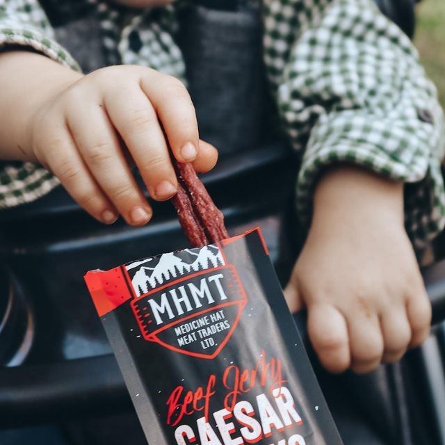Child’s hands holding MHMT Caesar beef jerky snack pack