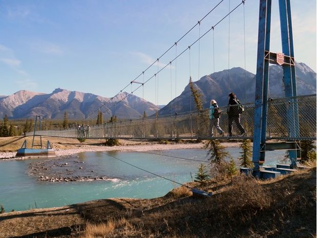 People walking across suspension bridge in David Thompson Country.