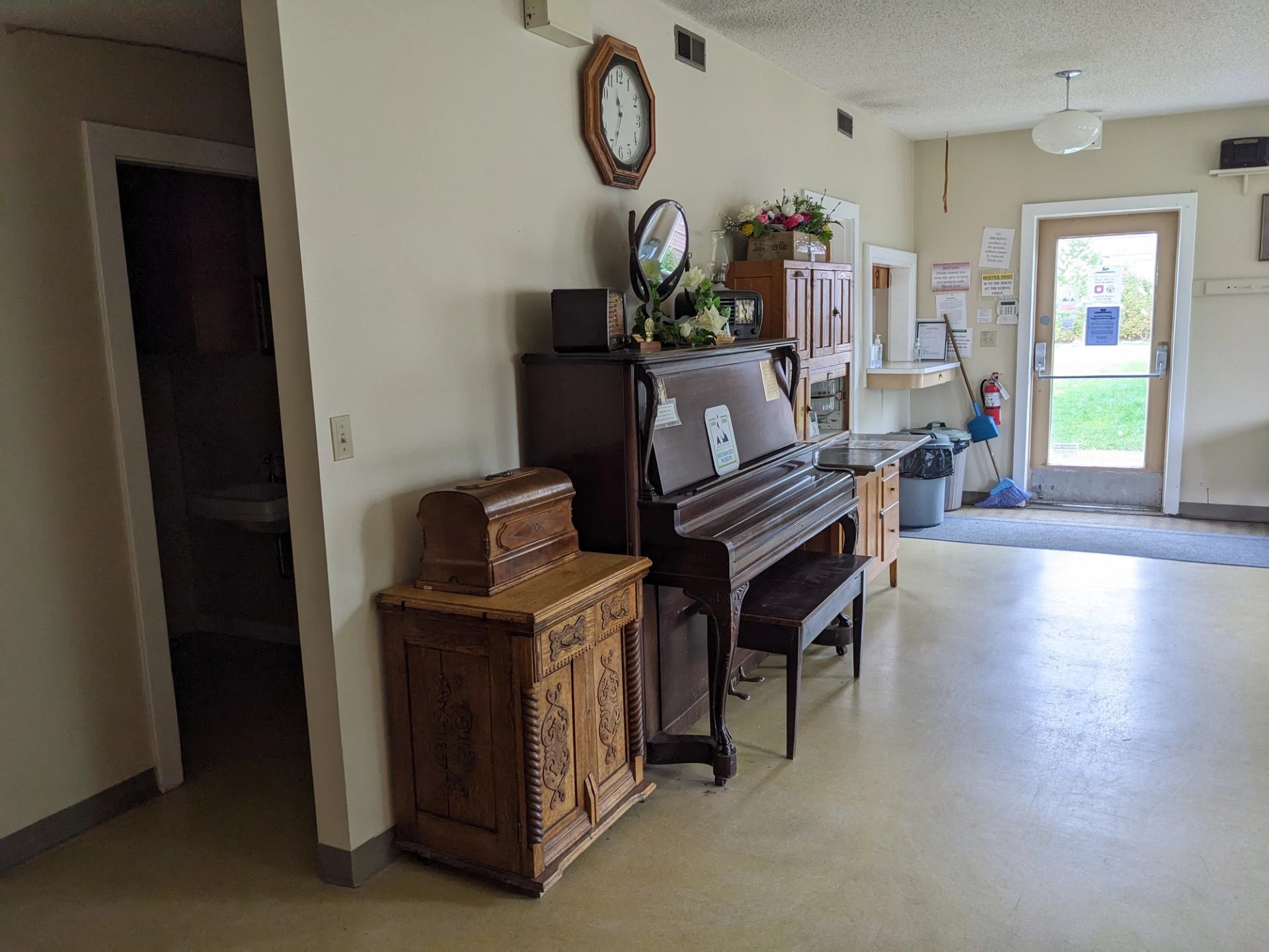 Cozy tea room interior with piano, clock, and vintage decor.