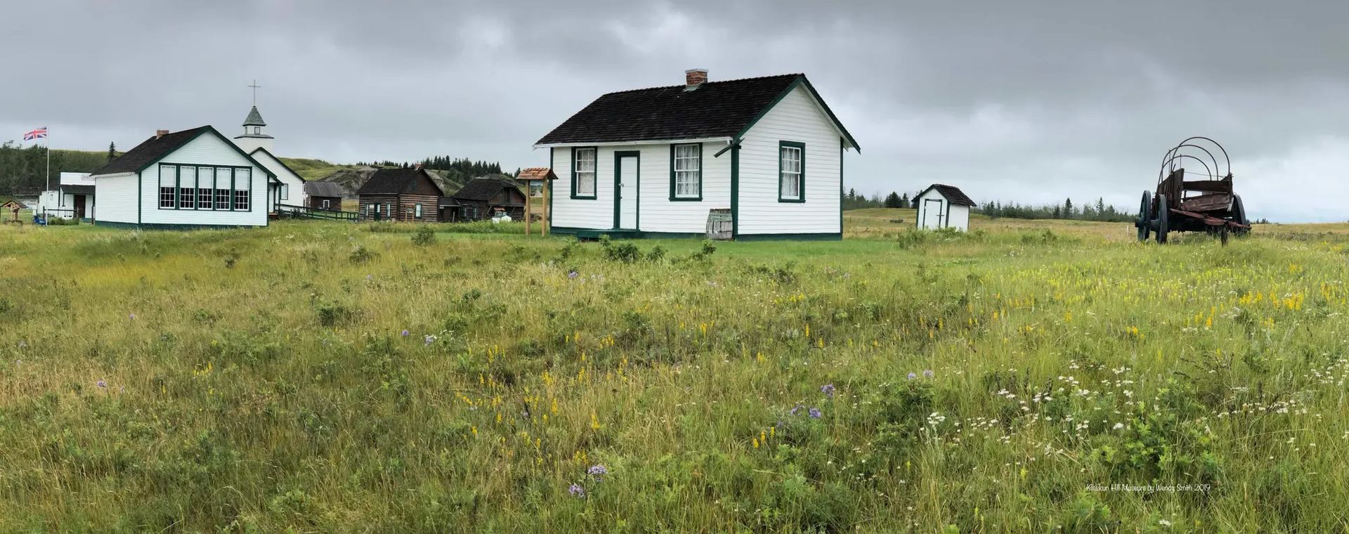 Historic buildings and farm equipment at Kleskun Hill Museum Society outdoors.