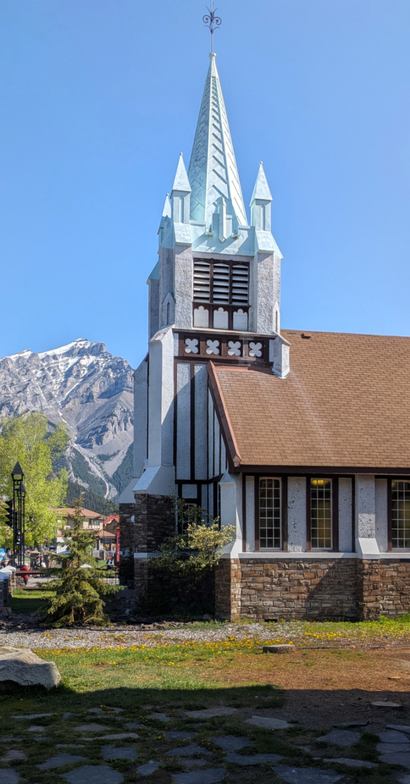 St. Paul's Presbyterian Church features a tall steeple with mountains rising in the background.